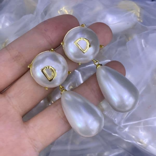 Classic pearl pendant earrings with gold plating and gold letter accents. These are trendy and simple, designed as pendant earrings for jewelry.