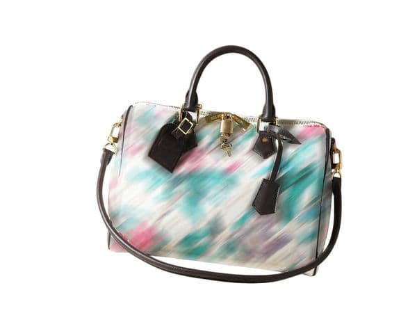 This designer bag features a color-block leather key pouch and name tag, with a zippered interior pocket and a detachable shoulder strap adding refi