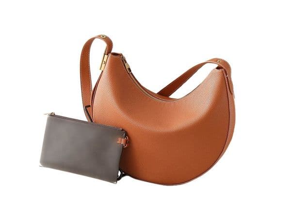 This designer handbag features soft cowhide that will develop a chic patina over time, a distressed metal lock, and detachable