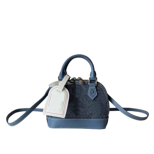 Designer handbag with top handle and detachable adjustable shoulder strap for versatile carrying options; interior space accommodates a compact wallet.